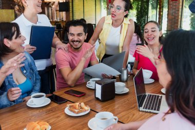 Latin takım çalışması kahvaltıda dizüstü bilgisayar ve not defteri kullanarak kafeteryada beyin fırtınası yapmak için bir araya geldi. Latin Amerika 'da çalışan kadın ve erkekler