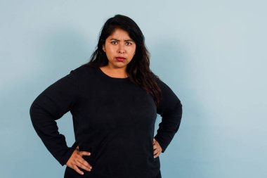 Latin Amerikalı artı boyut ve Meksika Latin Amerika 'da mavi arka planda fotokopi alanı olan kızgın kadın, İspanyol rahatsız olmuş kadın portresi.