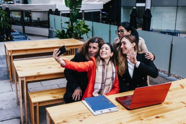 Farklı yaşlarda çalışan İspanyol iş adamları şehrin parkında kışın birlikte fotoğraf çektiriyorlar. Kentsel alanda çeşitli Latin Girişimciler ve çoklu jenerasyon takım çalışması