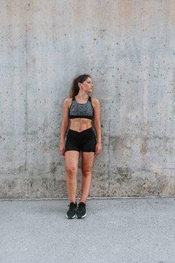 Açık havada spor giyimli genç İspanyol kadının portresi.