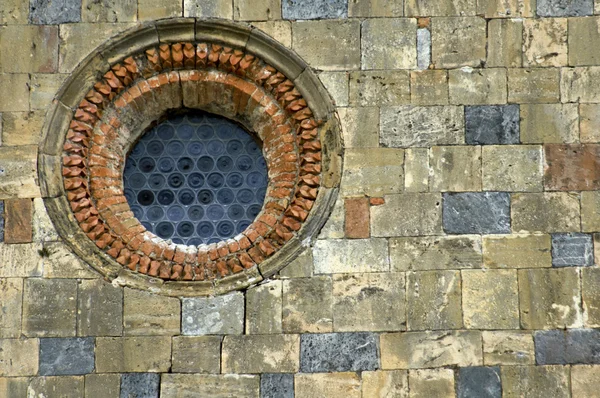 Finestra rotonda, muro di pietra — Foto Stock