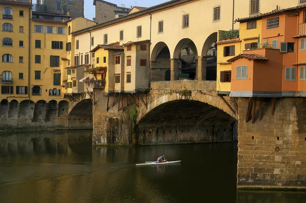 Man rowing shell beneath the Ponte Vecchio — Stock Photo, Image