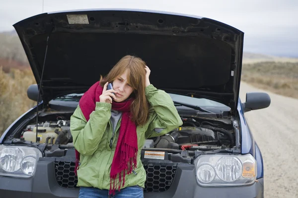 Jeune fille avec une voiture cassée — Photo