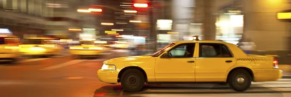 Taxi por la noche, borroso de movimiento — Foto de Stock