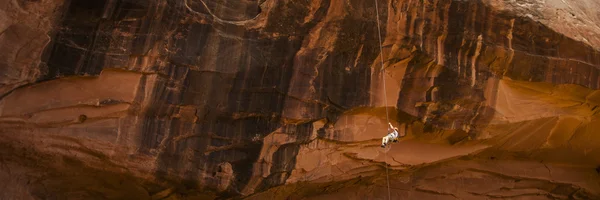 Rock alpinista rapel para baixo laranja penhasco Imagens De Bancos De Imagens