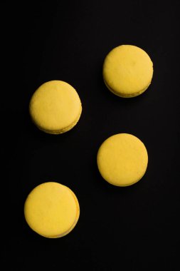 Fransız makarnası. Siyah arka planda izole edilmiş sarı makarna yığını. Makaronlar.