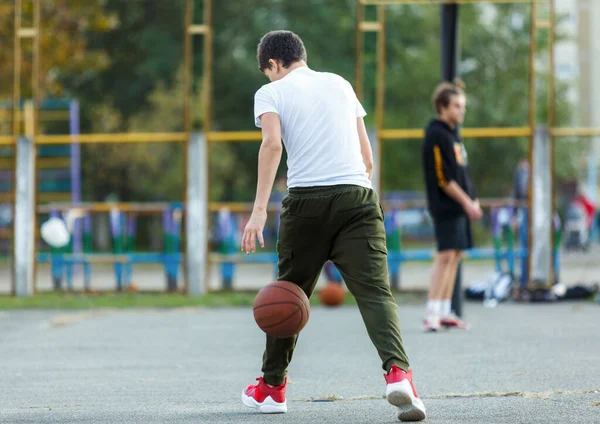 Милый Мальчик Играет Баскетбол Улице Подросток Белой Футболке Оранжевым Баскетбольным — стоковое фото