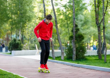 Gençler boş zamanlarını şehir parkında paten yaparak geçirirler. Serbest stilde pratik yapmak, numaralar yapmak. Şirin bir çocuk kaykayıyla güneşli bir günün tadını çıkarıyor. Hobi, spor