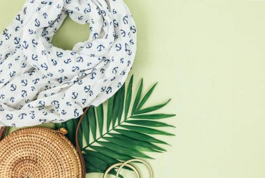 Tropik palmiye yaprakları, yeşil arka planda hasır şapka. Moda tropikal desen. Moda kıyafetleri ve aksesuarlar. Düz yatıyordu. Yaz, tatil, tatil konsepti.