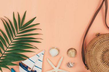 Tropik palmiye yaprakları, hasır şapka, denizyıldızı, pastel mercan turuncu arka planda deniz kabukları. Moda tropikal desen. Moda kıyafetleri ve aksesuarlar. Düz yatıyordu. Yaz, tatil, tatil konsepti.