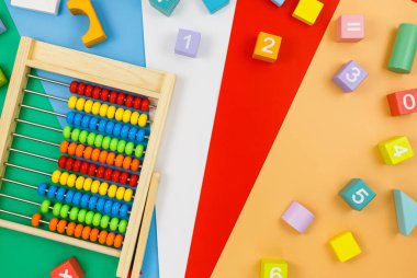 Kırmızı mavi arka planda çok renkli ahşap bloklar. Moda bulmaca oyuncakları. Geometrik şekiller: kare, daire, üçgen, dikdörtgen. Anaokulu, anaokulu ya da kreş için eğitici oyuncaklar. Okula geri dön.