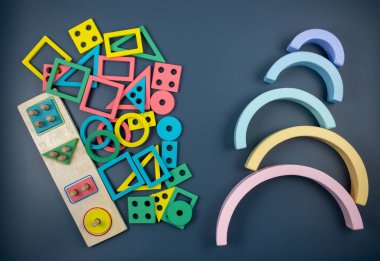 Mavi arka planda çok renkli ahşap bloklar. Moda bulmaca oyuncakları. Geometrik şekiller: kare, daire, üçgen, dikdörtgen. Anaokulu, anaokulu ya da kreş için eğitici oyuncaklar. Okula geri dön.