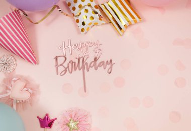 Doğum günü kutlaması ya da parti için arka plan. Renkli balonlar, konfetiler, mumlar, pastel pembe arka planda kurdeleler. Kopyalama alanı olan bir model, metin için bir yer