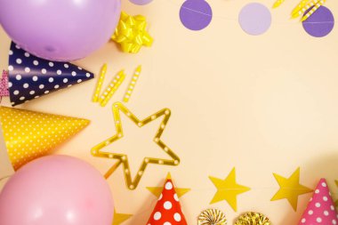 Doğum günü kutlaması ya da parti için arka plan. Renkli balonlar, konfeti, mumlar, bej renkli pastel arka planda şeritler. Metin için bir yer olan kopyalama alanı kullan