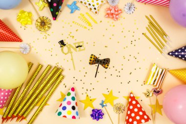 Doğum günü kutlaması ya da parti için arka plan. Renkli balonlar, konfeti, mumlar, bej renkli pastel arka planda şeritler. Metin için bir yer olan kopyalama alanı kullan