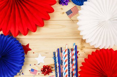 Amerikan bağımsızlığının 4 Temmuz günü için dekorasyonlar, bayrak, mumlar, pipetler, kağıt hayranları. Tahta arka planda ABD tatil süslemeleri, üst manzara, düz yatış