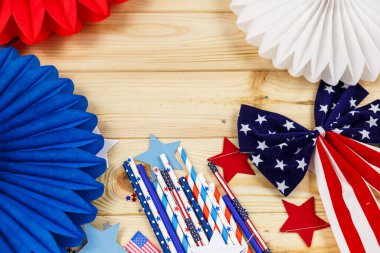 Amerikan bağımsızlığının 4 Temmuz günü için dekorasyonlar, bayrak, mumlar, pipetler, kağıt hayranları. Tahta arka planda ABD tatil süslemeleri, üst manzara, düz yatış