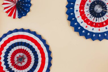 Amerikan bağımsızlığının 4 Temmuz günü için dekorasyonlar, bayrak, mumlar, pipetler, kağıt hayranları. Bej arka planda ABD tatil süslemeleri, üst manzara, düz yatış