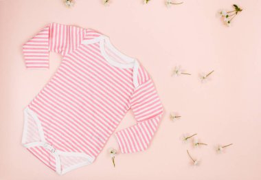 Pembe masada yeni doğmuş bir çocuk için pembe bir beden. Çevre dostu tahta oyuncaklarla organik pamuktan bebek bedeni modeli. Bebek partisi, festival, doğum günü süsü. Üst görünüm