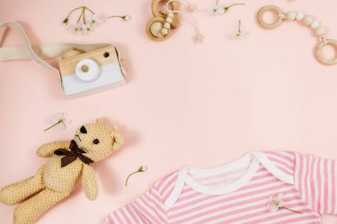 Pembe masadaki yeni doğmuş bir çocuk için pembe beden, ayı ve aksesuarlar. Çevre dostu tahta oyuncaklarla organik pamuktan bebek bedeni modeli. Bebek partisi, festival, doğum günü süsü. Üst görünüm