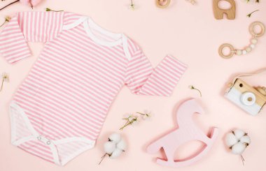 Pembe masadaki yeni doğmuş bir çocuk için pembe beden, ayı ve aksesuarlar. Çevre dostu tahta oyuncaklarla organik pamuktan bebek bedeni modeli. Bebek partisi, festival, doğum günü süsü. Üst görünüm