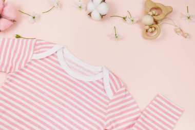 Pembe masadaki yeni doğmuş bir çocuk için pembe beden, ayı ve aksesuarlar. Çevre dostu tahta oyuncaklarla organik pamuktan bebek bedeni modeli. Bebek partisi, festival, doğum günü süsü. Üst görünüm