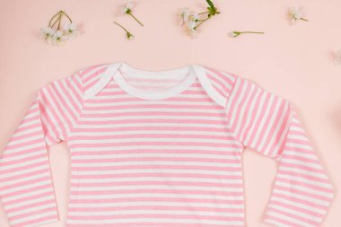 Pembe masada yeni doğmuş bir çocuk için pembe bir beden. Çevre dostu tahta oyuncaklarla organik pamuktan bebek bedeni modeli. Bebek partisi, festival, doğum günü süsü. Üst görünüm