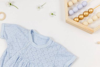 Beyaz masada yeni doğmuş bir çocuk için mavi beden, ayı ve aksesuarlar. Çevre dostu tahta oyuncaklarla organik pamuktan bebek bedeni modeli. Bebek partisi, festival, doğum günü süsü. Üst görünüm