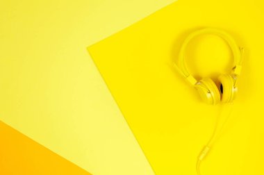 Sarı kulaklıklar sarı arka planda. Müzik konsepti.