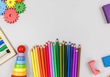 Çok renkli tahta bloklar, gri arka planda kalemler. Moda çevre dostu yapboz oyuncakları. Anaokulu ve anaokulu için eğitici oyuncaklar. Okula geri dön..