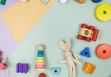 Menekşe rengi, yeşil, bej arka planda çok renkli ahşap oyuncaklar. Anaokulu veya kreş oyunları, eğitim