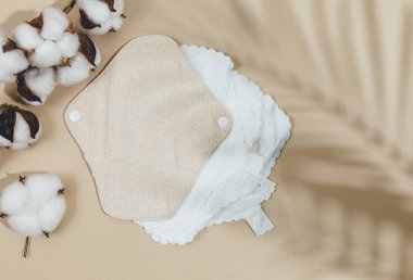 Bej arka planda pamuk dalıyla adet günleri için yeniden kullanılabilir doğal pedler. Yeniden kullanılabilir, sağlıklı ve çevre dostu pedler. Sıfır atık, sürdürülebilir yaşam tarzı.