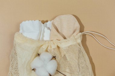 Bej arka planda pamuklu adet günleri için yeniden kullanılabilir doğal pedler. Çantada yeniden kullanılabilir, sağlıklı ve çevre dostu pedler var. Sıfır atık, sürdürülebilir yaşam tarzı.