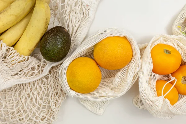Färsk Frukt Grönsaker Ekologiska Bomullspåsar Ett Beige Bord Morötter Apelsiner — Stockfoto