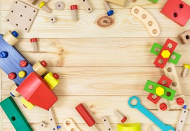 Tahtadaki çocuklar için renkli ahşap bir yapı seti. Ahşap masadaki aletler. Anaokulundaki ya da kreşteki çocuklar için oyunlar ve aletler. Doğal, çevre dostu oyuncaklar..