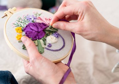 Evdeki dinlendirici bir öğleden sonra kumaşa, detaylara özen göstererek güzel bir çiçek nakışı yapmak.