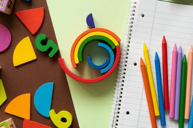 Parlak renkli geometrik oyuncaklar, masandaki kırtasiye malzemeleriyle birlikte düzenlenir, yaratıcılığı ve öğrenmeyi teşvik eder. Çocukları evde eğitici oyunlara çekmek için mükemmel..