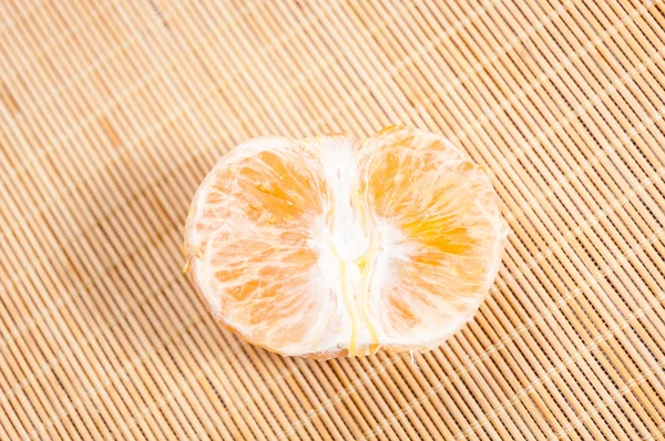 Half peeled tangerine on mat — Stock Photo, Image