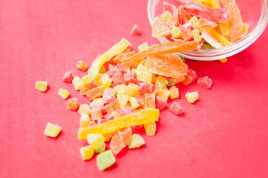 çok renkli bir cam kabın içinde ve yakın kase kırmızı bir arka plan üzerinde kurutulmuş ananas parçaları