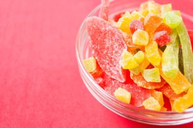 çok renkli bir cam kase kırmızı bir arka plan üzerinde kurutulmuş ananas parçaları