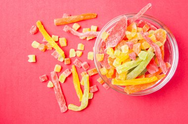 çok renkli bir cam kabın içinde ve yakın kase kırmızı bir arka plan üzerinde kurutulmuş ananas parçaları