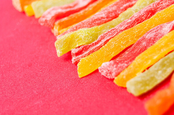 multi-colored slises dried pineapple on a red background