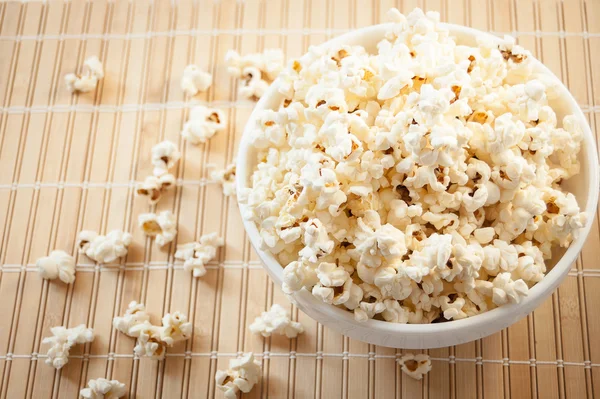 Beyaz bir kase patlamış mısır ve mindere döktüm