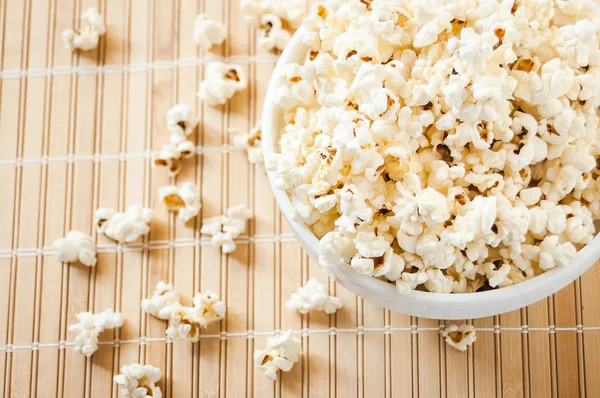 Beyaz bir kase patlamış mısır ve mindere döktüm