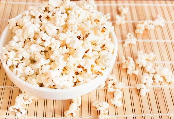 Beyaz bir kase patlamış mısır ve mindere döktüm