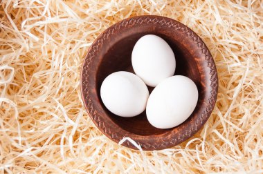 saman üzerinde seramik bir kasede beyaz tavuk yumurtası