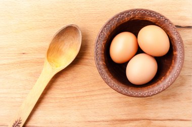 tavuk yumurtası seramik kase ve ahşap bir masa, organik ve diyet yemek kaşık