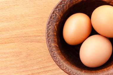 ahşap bir masa, organik ve Diyetetik gıda üzerinde seramik bir kapta tavuk yumurtası