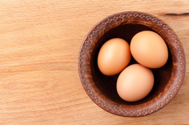 ahşap bir masa, organik ve Diyetetik gıda üzerinde seramik bir kapta tavuk yumurtası