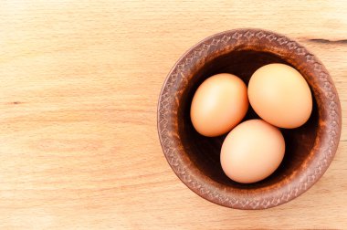 ahşap bir masa, organik ve Diyetetik gıda üzerinde seramik bir kapta tavuk yumurtası